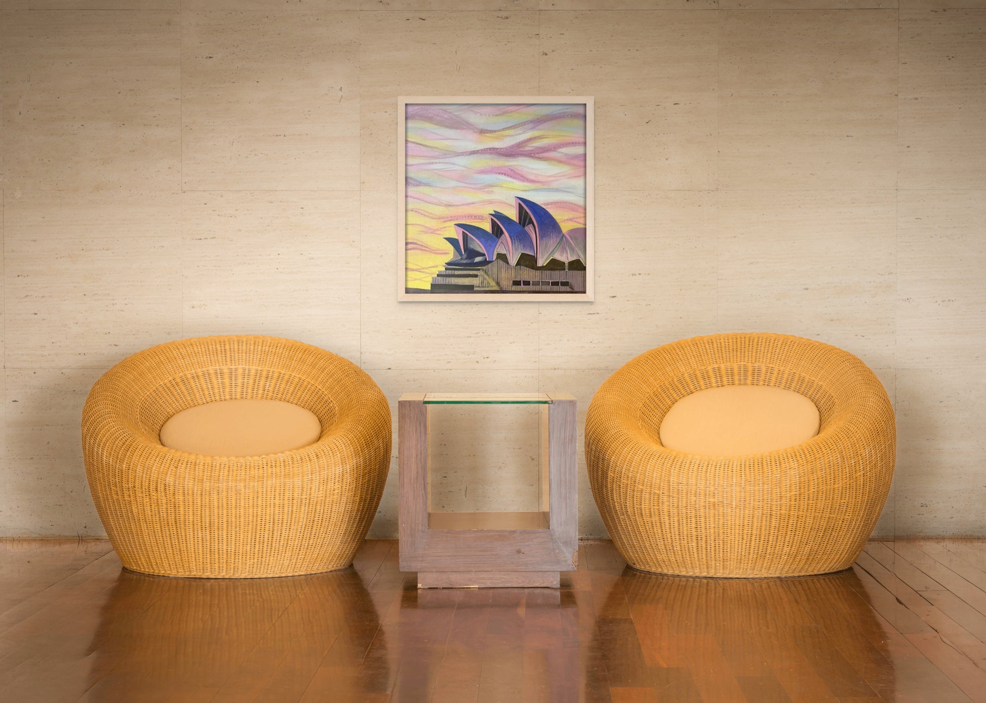 Painting of the Opera House at dusk hanging on a marble wall above two yellow wicker chairs.