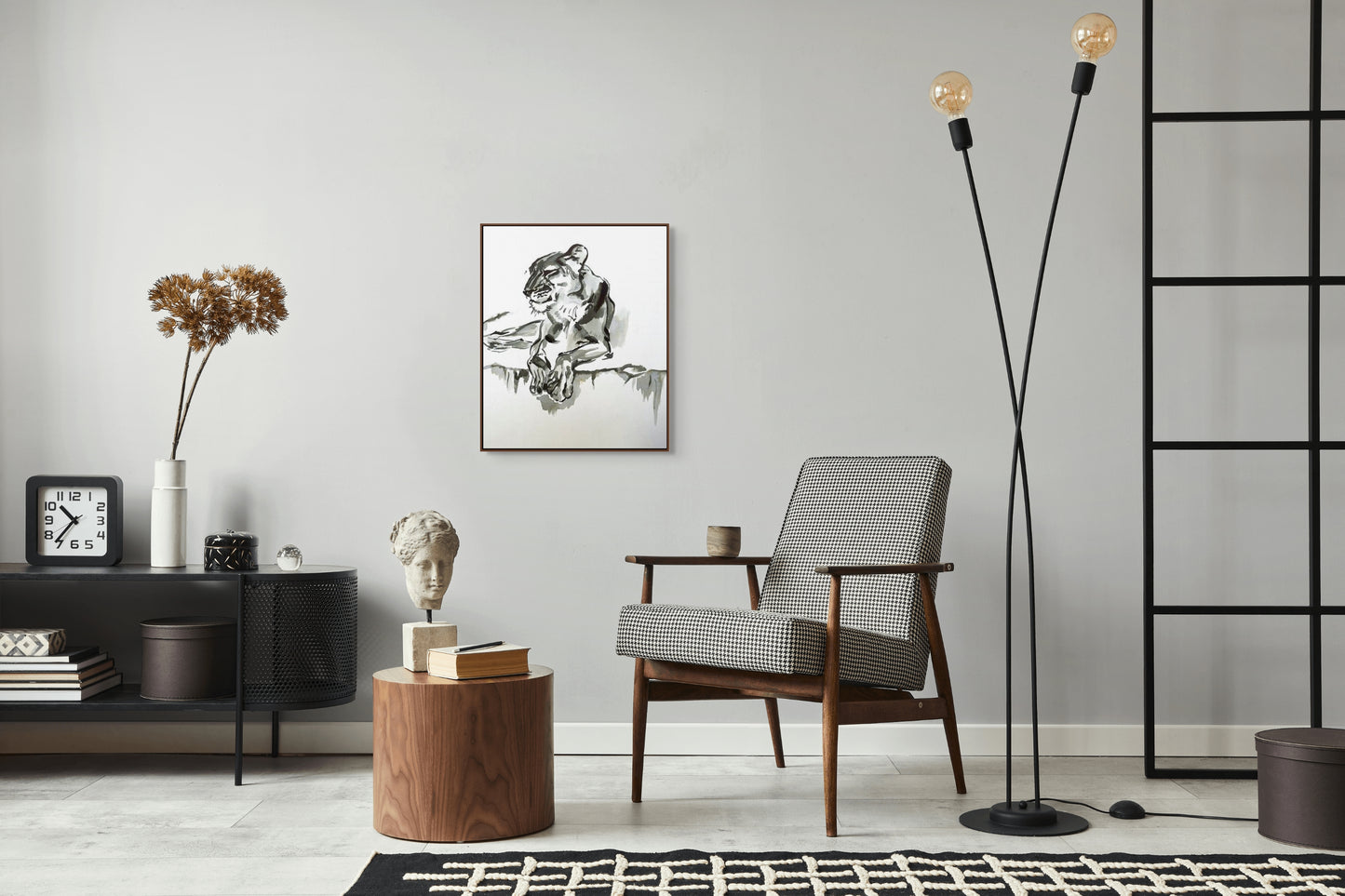 Framed painting of a lion hangs in a stylish modern lounge with mid-century furniture.