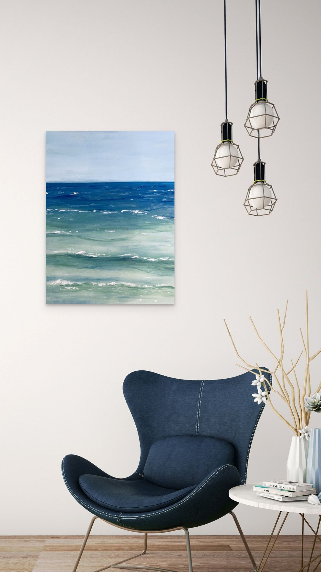 Painting of the sea hangs above a modern blue chair.