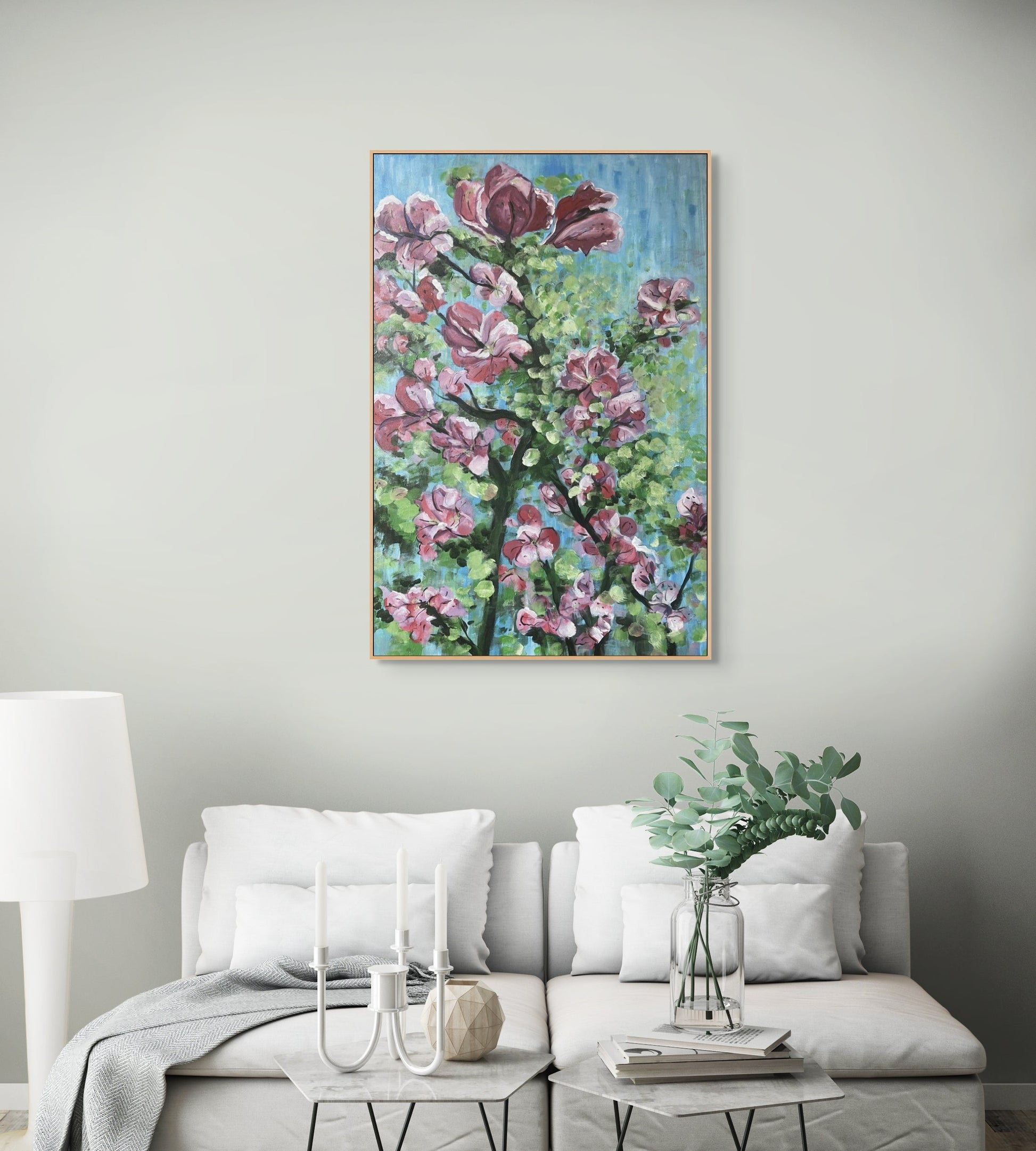 Painting of a pink bougainvillaea tree hanging in a white lounge setting.